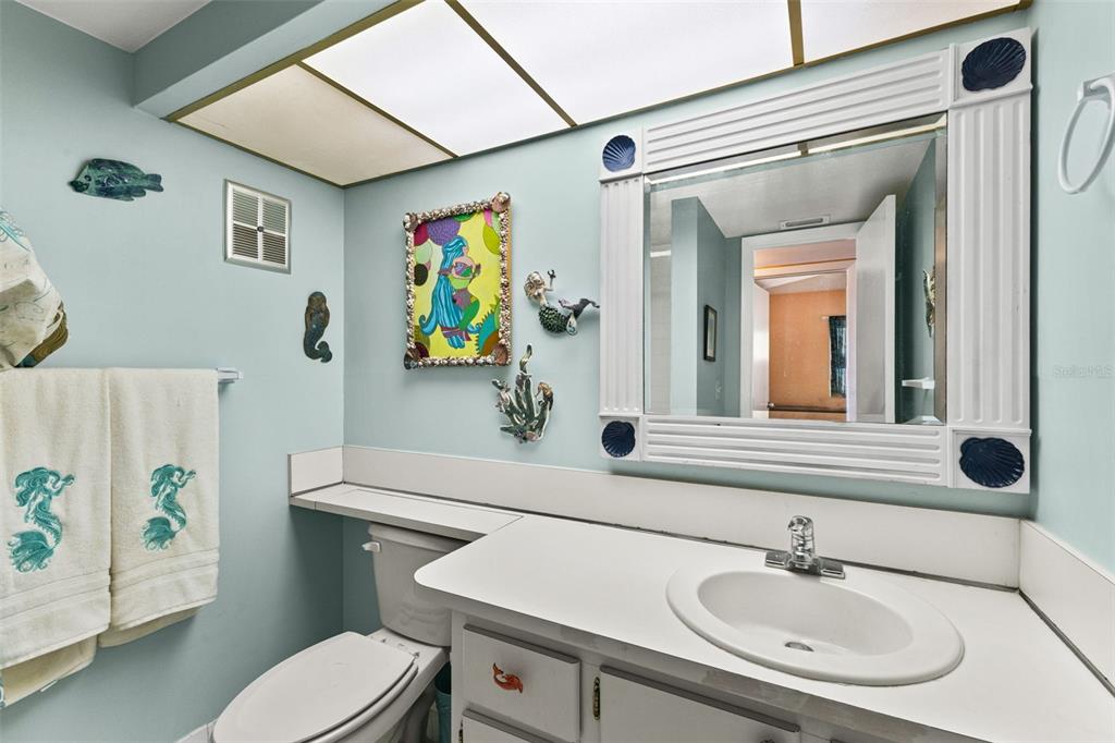4550 Cove Circle, Unit 501 St. Petersburg, FL 33708 - Photo 21 of 44 a bathroom with a sink a toilet and a mirror