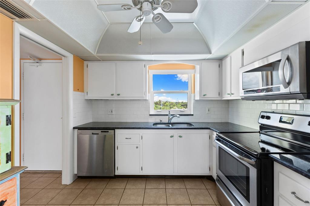 4550 Cove Circle, Unit 501 St. Petersburg, FL 33708 - Photo 9 of 44 a kitchen with stainless steel appliances granite countertop a sink and cabinets