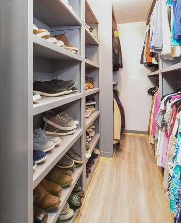 a view of walk in closet with clothes and shoes