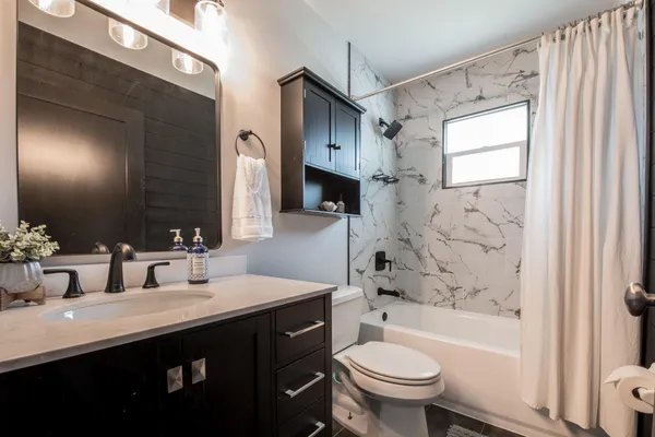 a bathroom with a double vanity sink toilet and shower