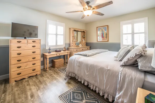 a bedroom with a bed and a flat tv screen on dresser