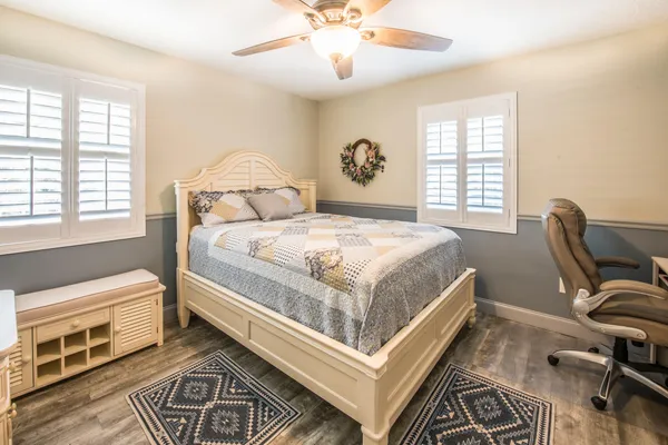 a bedroom with a bed wooden floor and window