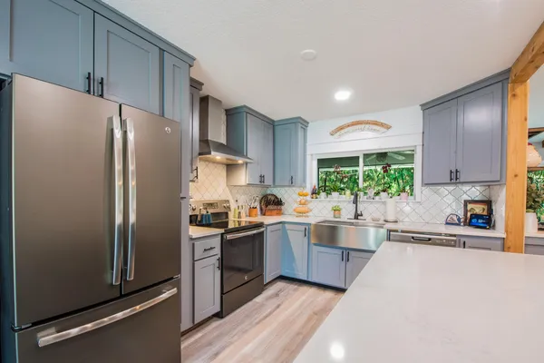a kitchen with stainless steel appliances granite countertop refrigerator a sink a stove and cabinets