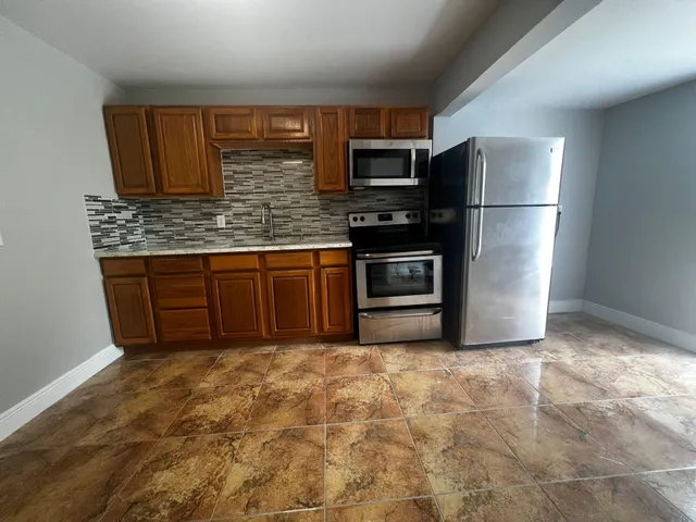 a kitchen with stainless steel appliances granite countertop a refrigerator stove and microwave