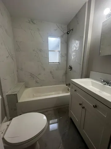 a bathroom with a tub sink and mirror