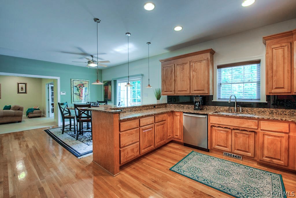 13340 Eppes Falls Road Chesterfield, VA 23838 - Photo 20 of 50 a large kitchen with stainless steel appliances granite countertop a stove a sink dishwasher a dining table and chairs with wooden floor