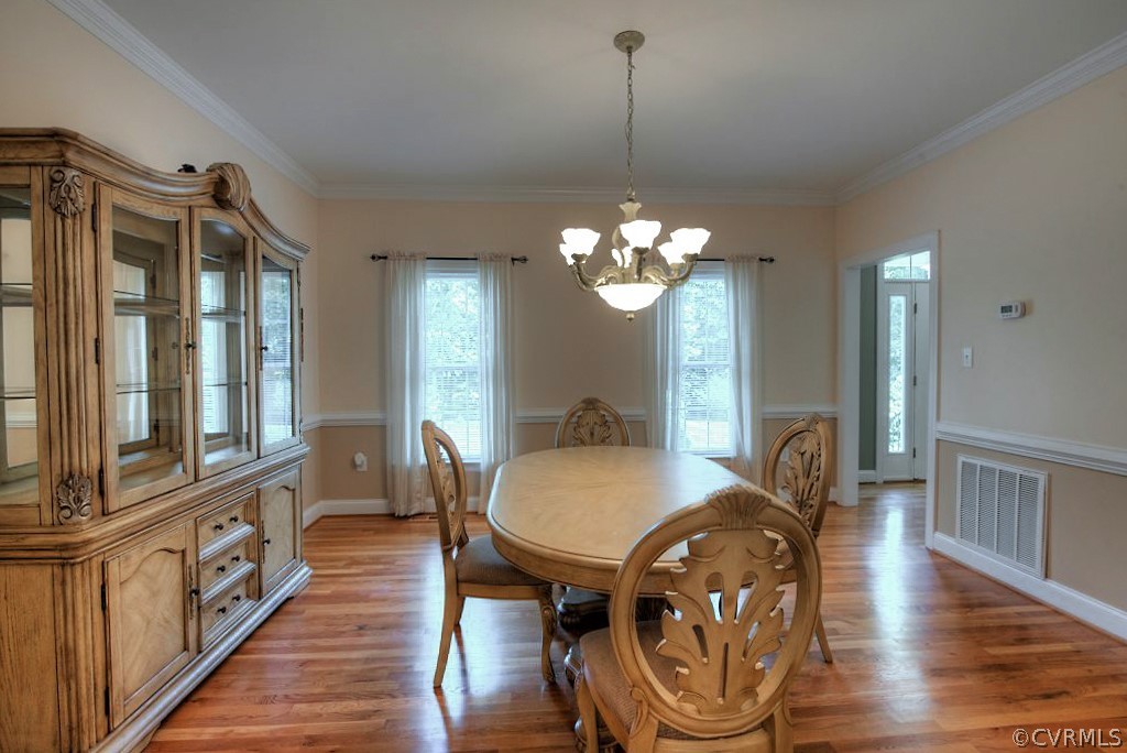13340 Eppes Falls Road Chesterfield, VA 23838 - Photo 23 of 50 a dining room with wooden floor a chandelier a wooden table and chairs