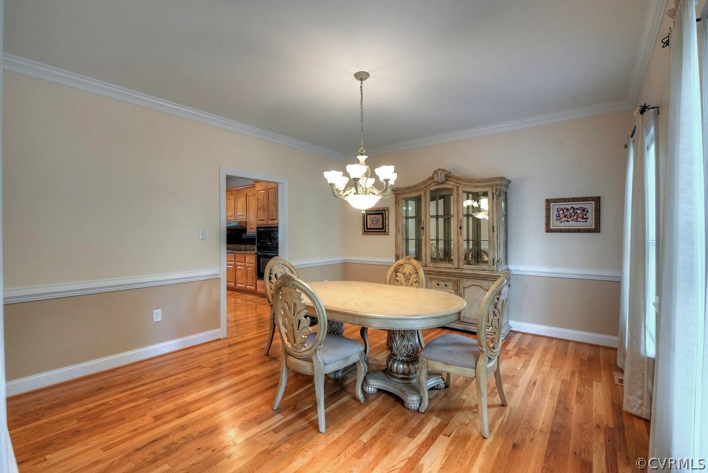 13340 Eppes Falls Road Chesterfield, VA 23838 - Photo 24 of 50 a dining room with furniture a chandelier and wooden floor