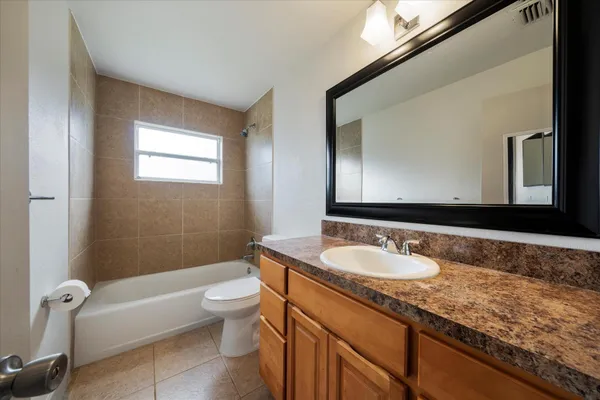 a bathroom with a granite countertop sink a toilet and a mirror