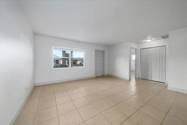 an empty room with windows and closet