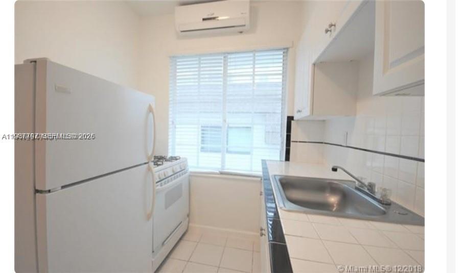 7936 Harding Avenue, Unit 5 Miami Beach, FL 33141 - Photo 5 of 6 a kitchen with a refrigerator sink and cabinets
