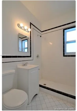 a bathroom with a toilet a sink and mirror
