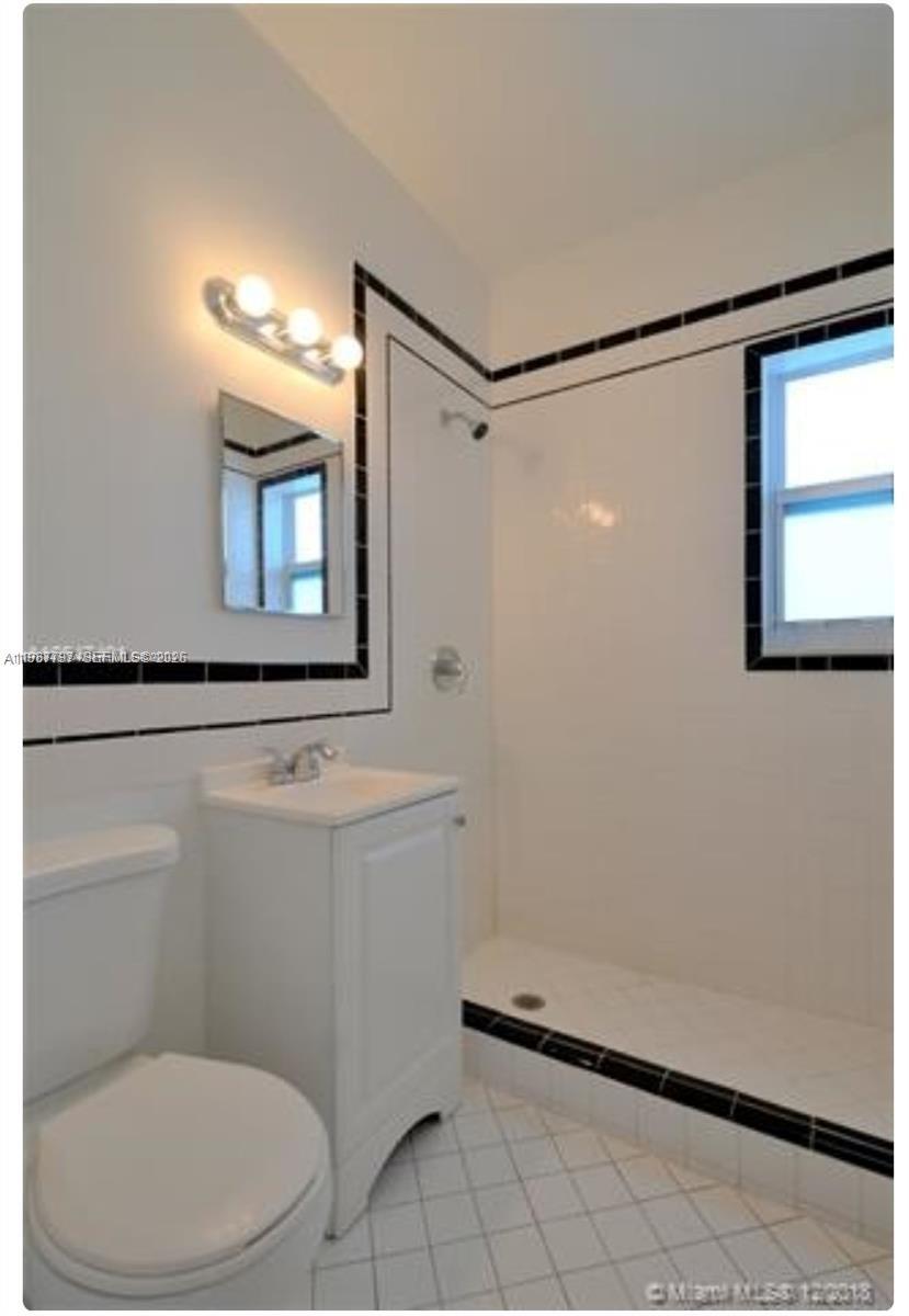 7936 Harding Avenue, Unit 5 Miami Beach, FL 33141 - Photo 6 of 6 a bathroom with a toilet a sink and mirror