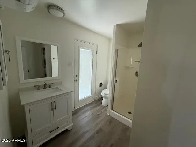 a bathroom with a granite countertop sink toilet and mirror