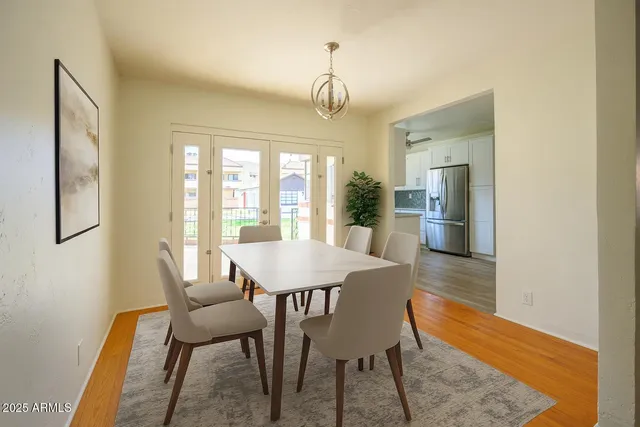 a dining room with furniture a chandelier and wooden floor