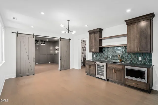 a large kitchen with stainless steel appliances granite countertop a refrigerator and a stove top oven