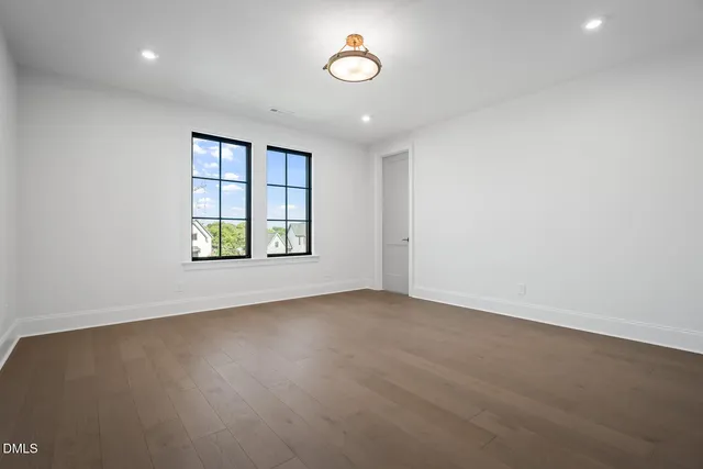 an empty room with a window and a ceiling fan