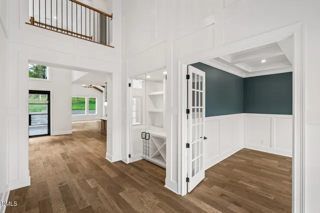 a view of a hallway with wooden floor and entryway with a living room