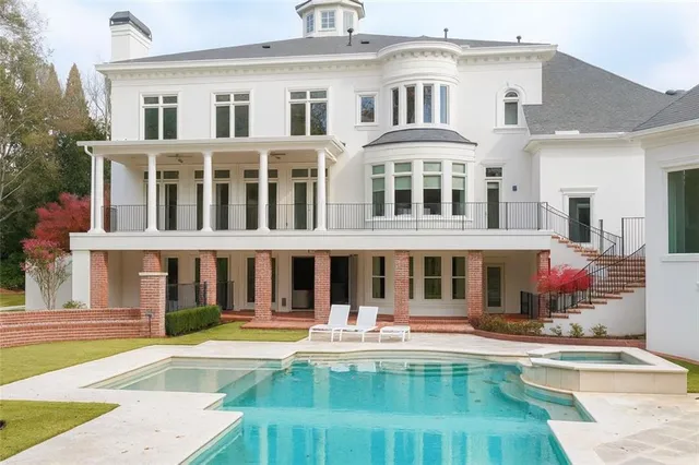 a view of swimming pool with seating area and trees around