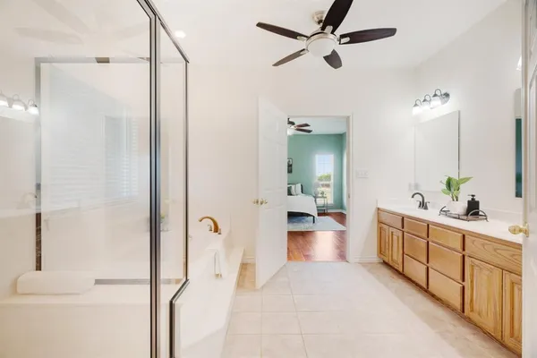 a spacious bathroom with a double vanity sink a mirror and shower