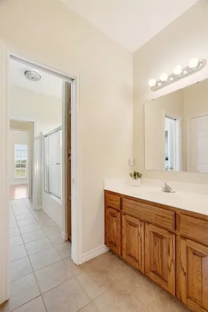 a spacious bathroom with a double vanity sink a mirror and a shower