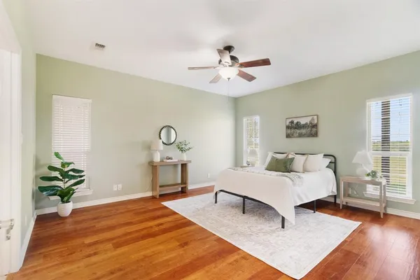 a bedroom with a bed chandelier and a window
