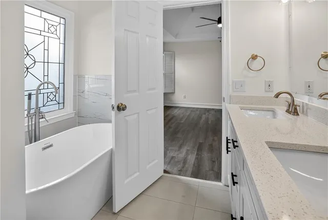 a bathroom with a tub sink and mirror