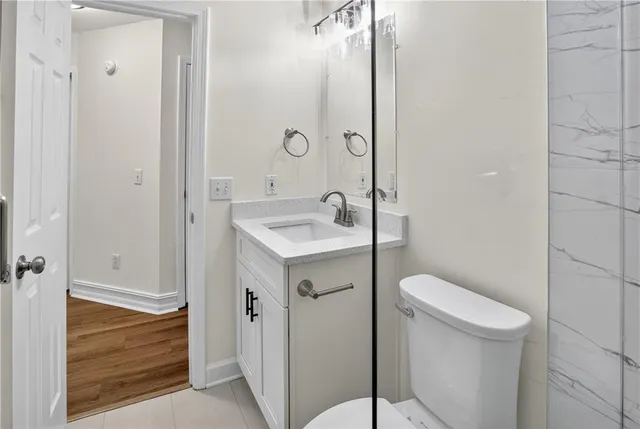 a bathroom with a sink a toilet and shower