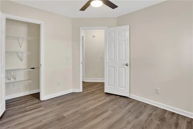 an empty room with wooden floor a ceiling fan