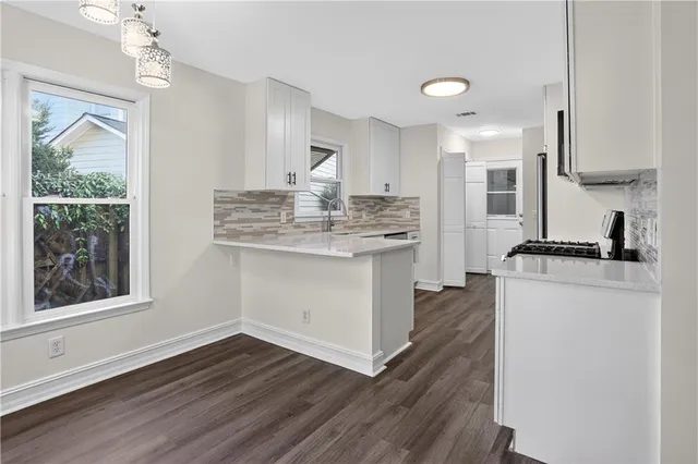 a kitchen with kitchen island white cabinets and stainless steel appliances