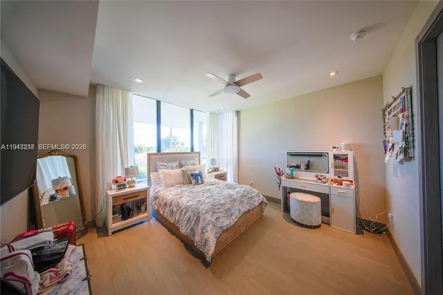 a bedroom with a bed and a flat tv screen on the dresser