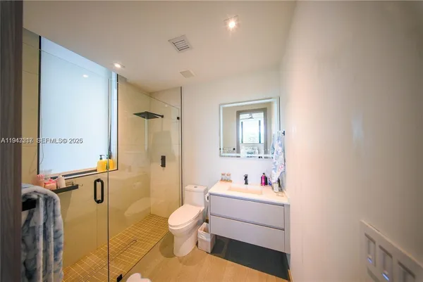 a bathroom with a sink mirror vanity and toilet