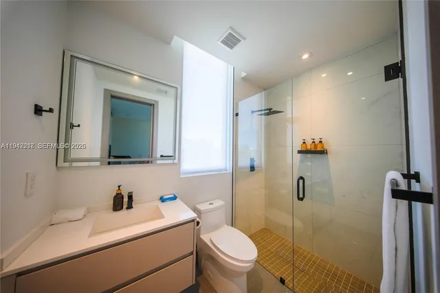 a bathroom with a sink toilet vanity and shower