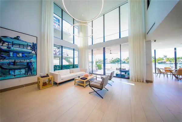a living room with furniture and floor to ceiling windows