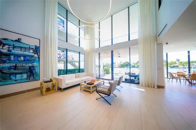 a living room with furniture and floor to ceiling windows