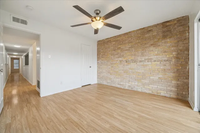 wooden floor in an empty room with a ceiling fan