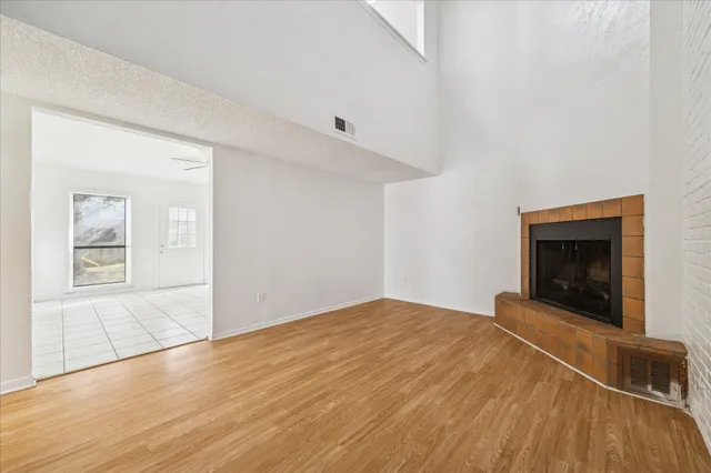 a view of empty room with wooden floor and fireplace
