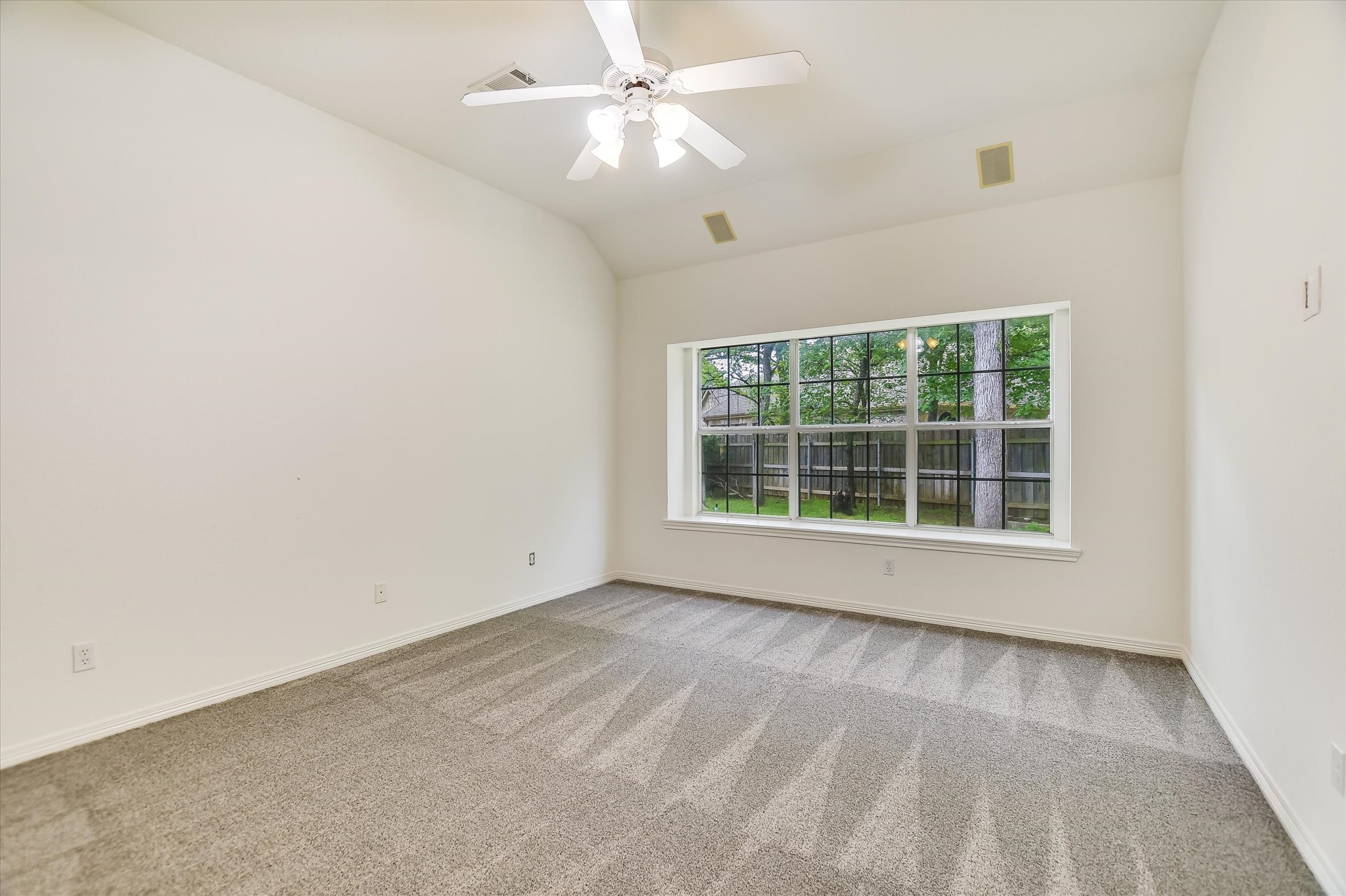 109 Stacey Cove Georgetown, TX 78628 - Photo 14 of 22 Primary bedroom with new carpeting and a vaulted ceiling that overlooks the backyard.