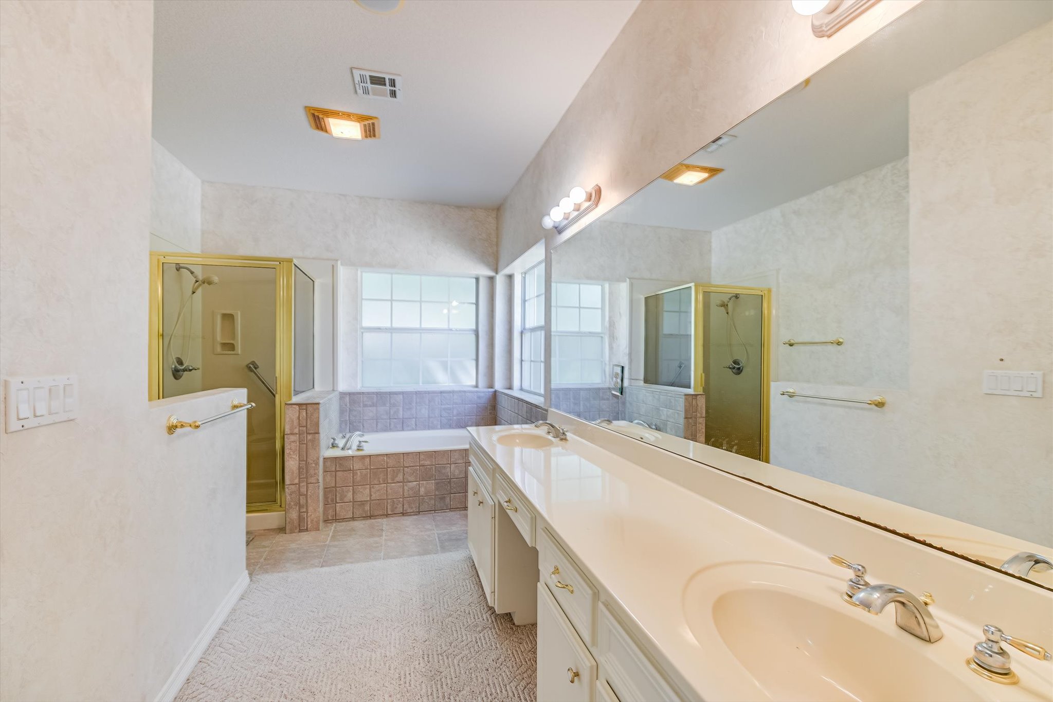 109 Stacey Cove Georgetown, TX 78628 - Photo 16 of 22 Primary bathroom with a double vanity, shower stall, and a garden tub.