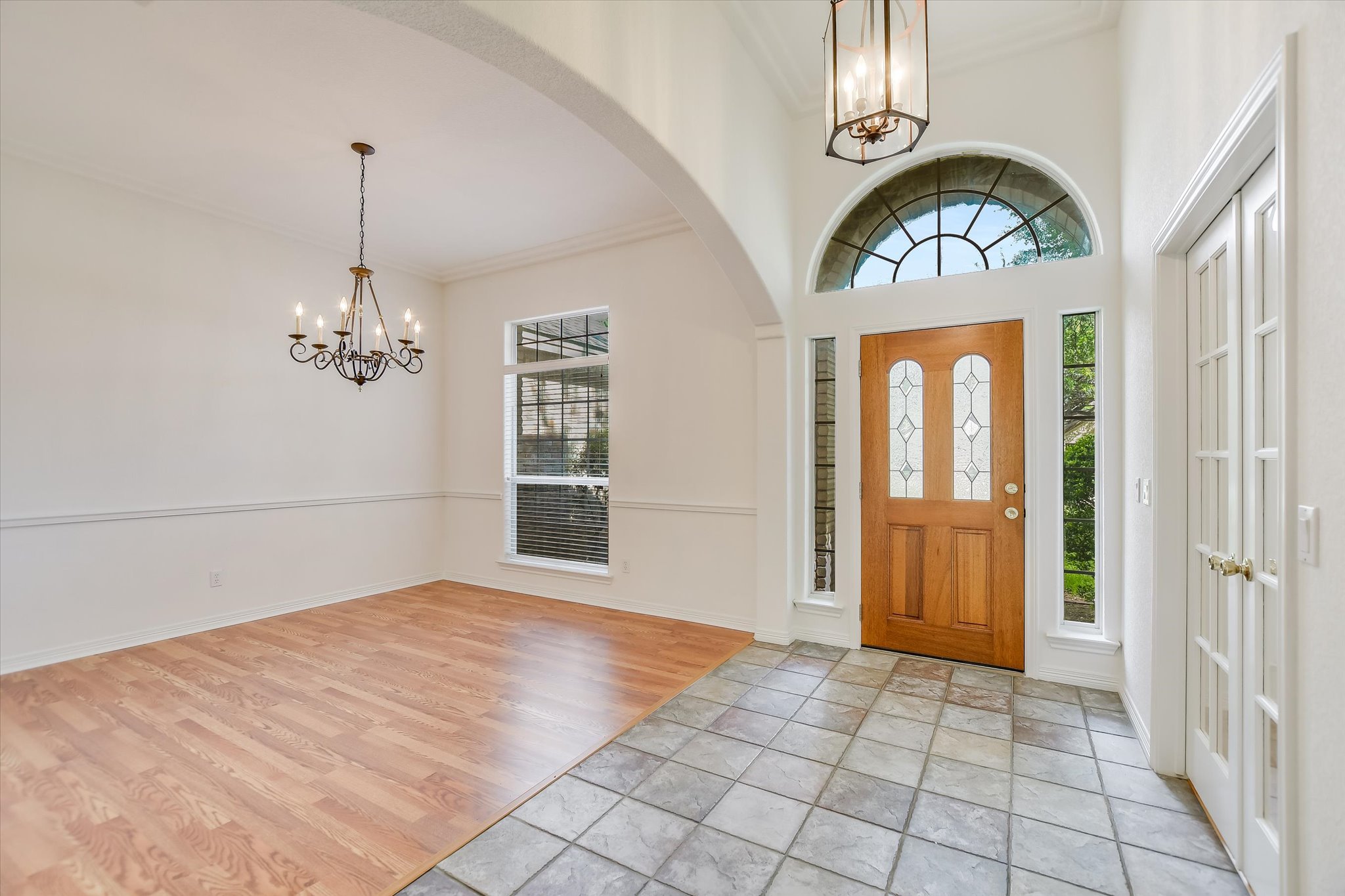 109 Stacey Cove Georgetown, TX 78628 - Photo 2 of 22 Foyer featuring suspended lighting, tiled floors, ornamental molding, and arched walkway.