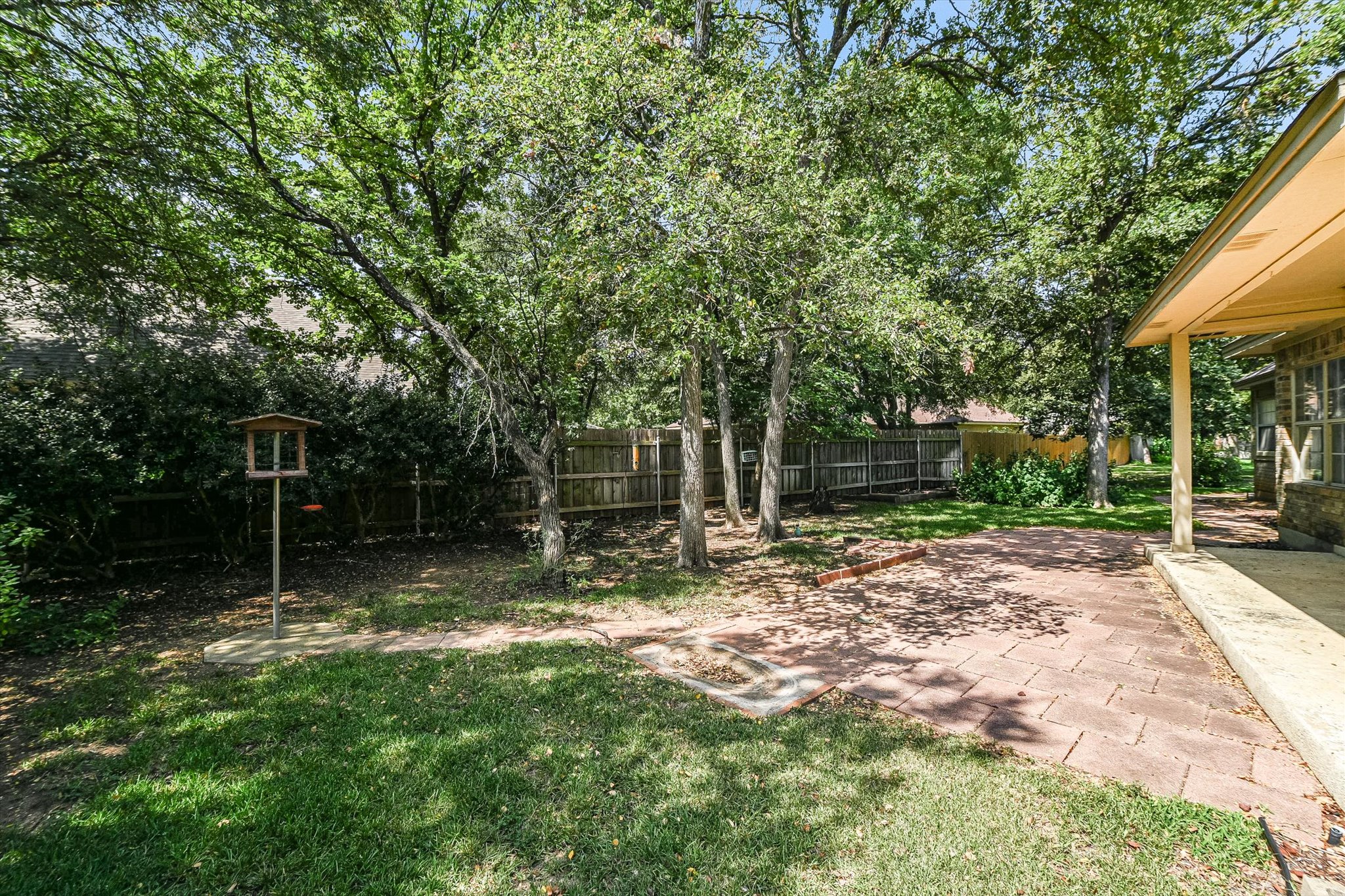 109 Stacey Cove Georgetown, TX 78628 - Photo 22 of 22 Fenced backyard surrounded by trees featuring a covered patio area.