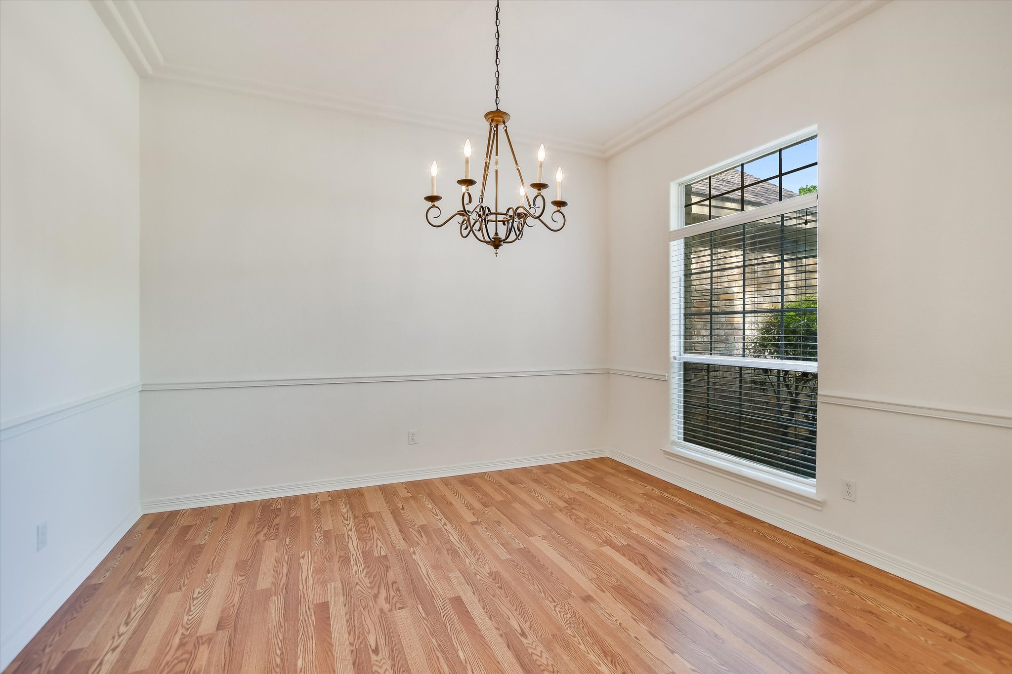 109 Stacey Cove Georgetown, TX 78628 - Photo 3 of 22 Dining room featuring arch entry with light wood-style floors, crown molding, and a hanging chandelier.