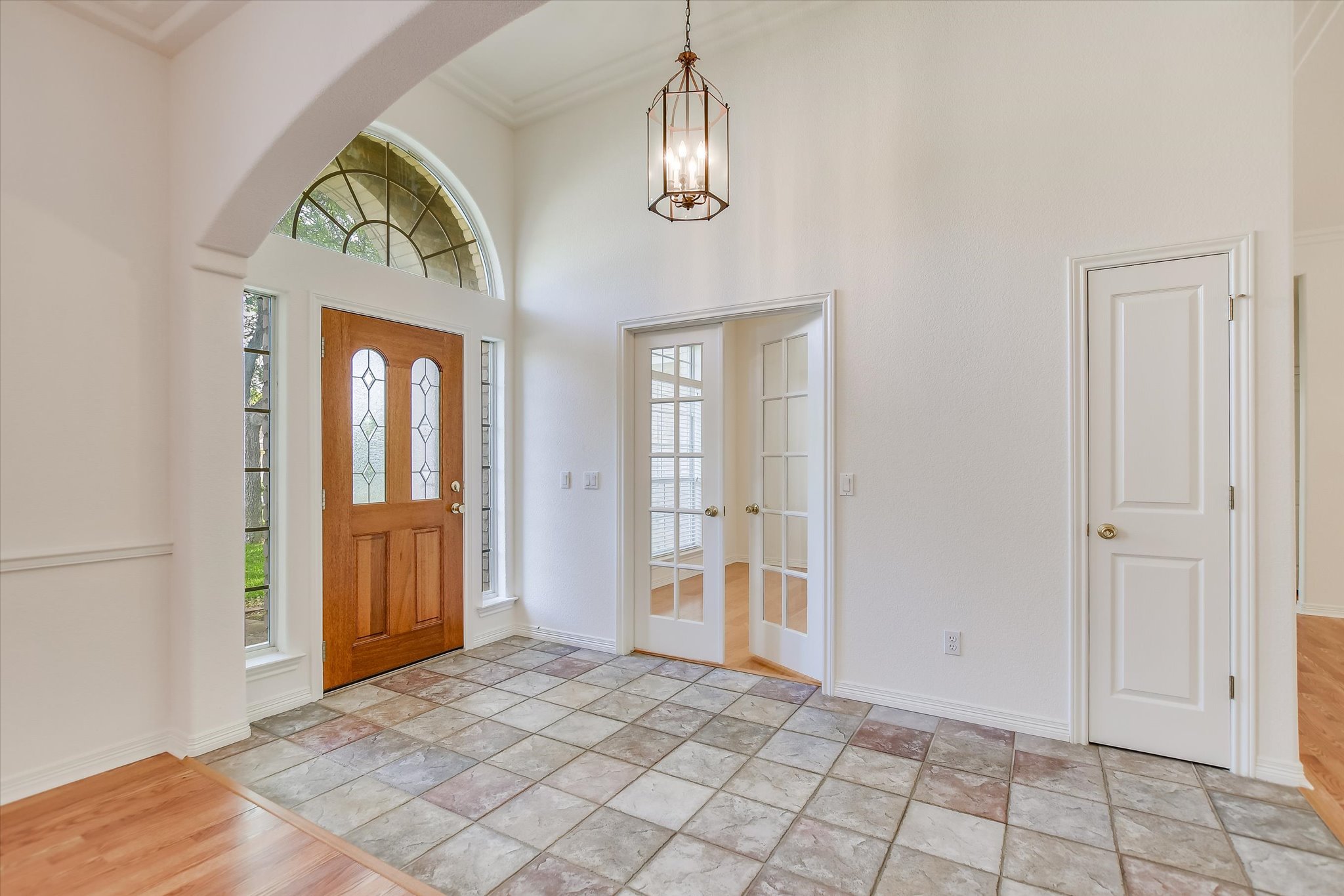 109 Stacey Cove Georgetown, TX 78628 - Photo 5 of 22 Foyer featuring suspended lighting, tiled floors, ornamental molding, and french doors opening to the office space.