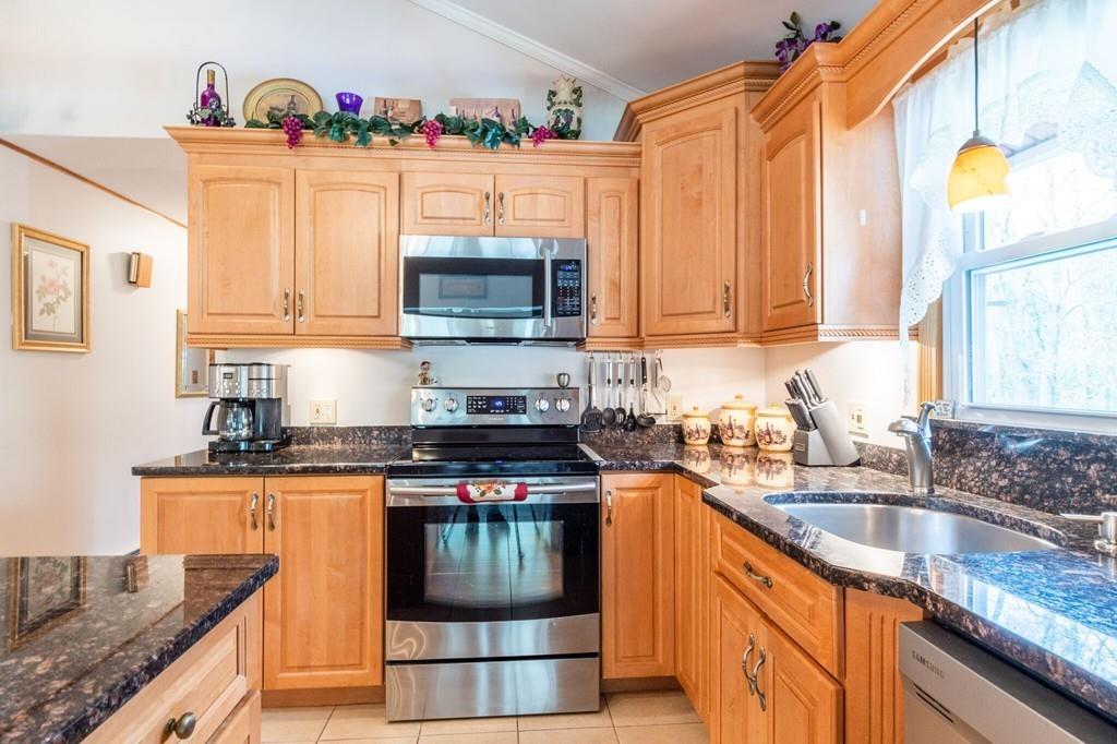 2 Old County Road Pelham, NH 03076 - Photo 4 of 38 a kitchen with granite countertop a sink a stove and a wooden cabinets