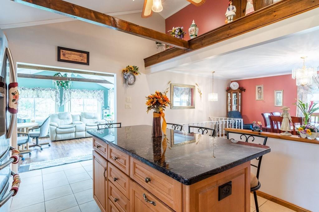 2 Old County Road Pelham, NH 03076 - Photo 6 of 38 a kitchen with stainless steel appliances granite countertop a table chairs and a barbeque