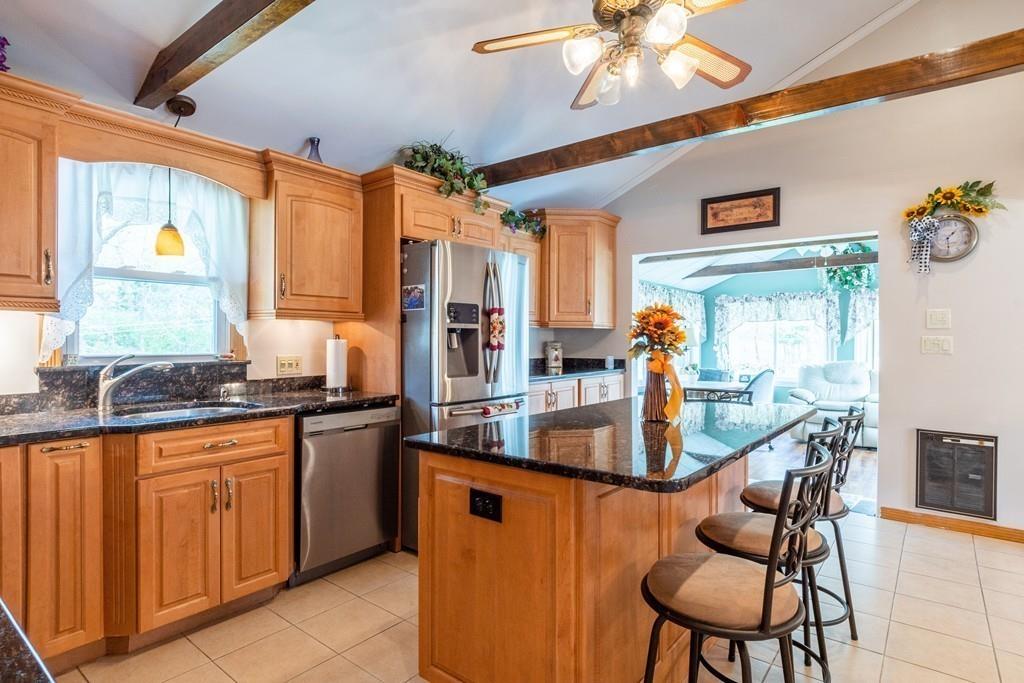2 Old County Road Pelham, NH 03076 - Photo 10 of 38 a kitchen with stainless steel appliances granite countertop a stove a sink dishwasher and a dining table with cabinets