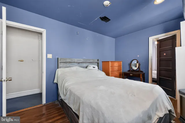 a large bed in a bedroom next to a window and a chandelier