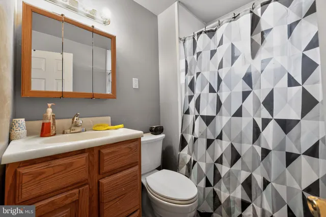 a bathroom with a granite countertop toilet sink and mirror