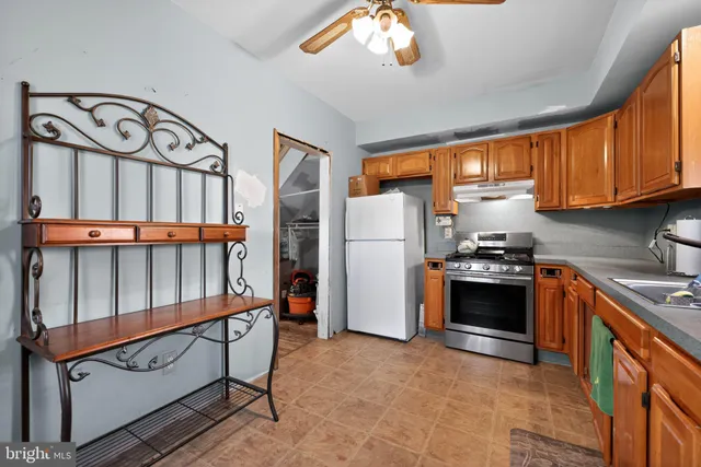 a kitchen with stainless steel appliances granite countertop a refrigerator a stove a sink and dishwasher