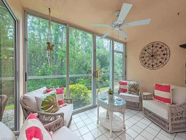 a living room filled with furniture and a floor to ceiling window